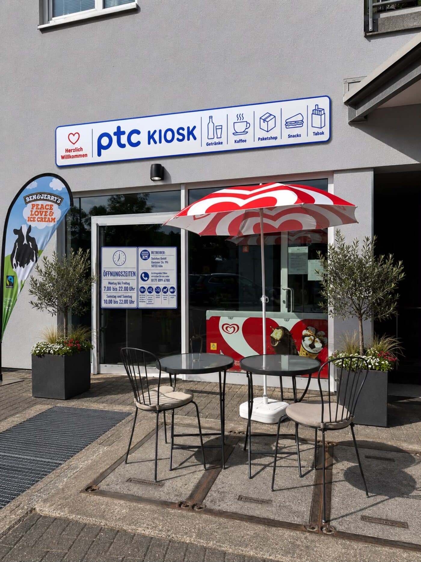 Visualisierung des ptc KIOSK von außen - mit Terrasse, Sonnenschirm und Eistruhe (KI-generiert)